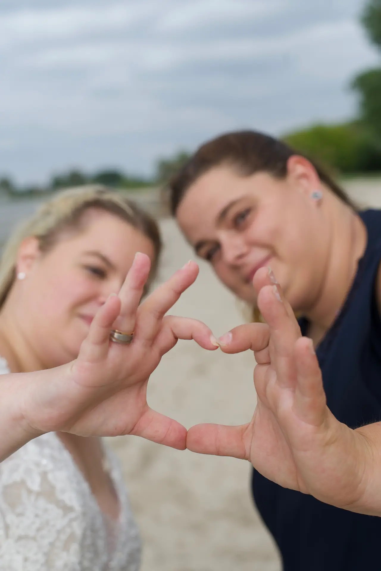 Zwei Frauen bilden aus Ihren Fingern ein Herz.