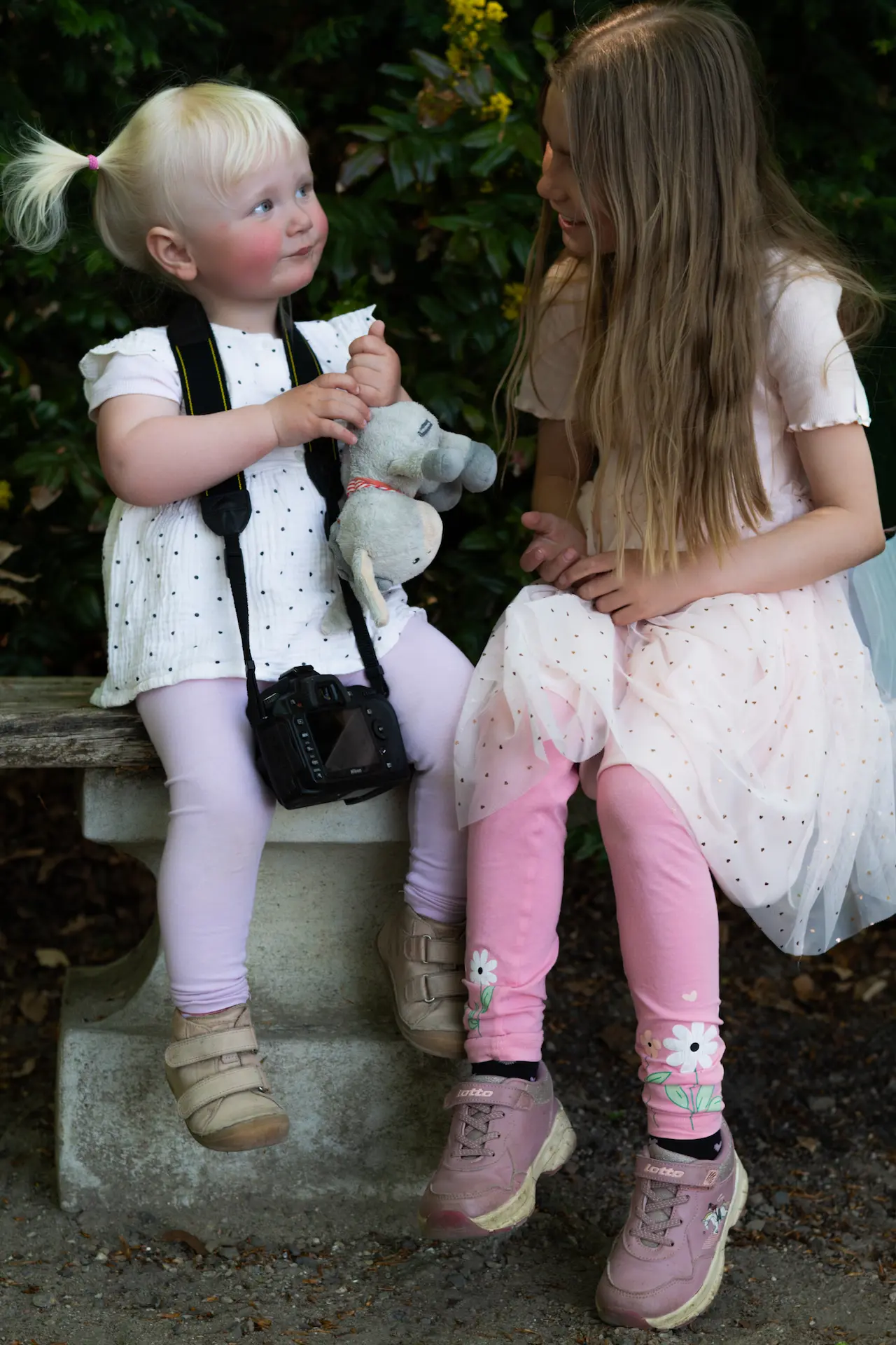Kinder-Fotoshooting: Zwei kleine Schwestern schauen sich genseitig liebevoll an.