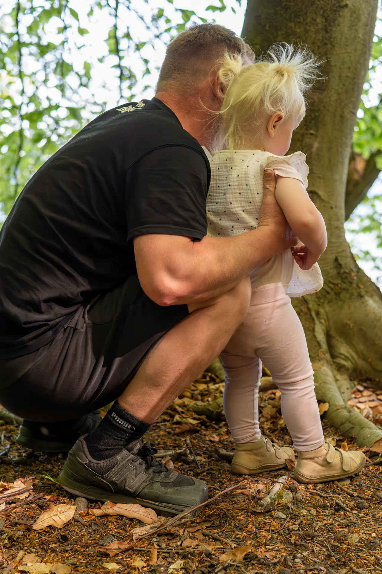 Vater und Kind im Familien-Portrait in einem Wald.