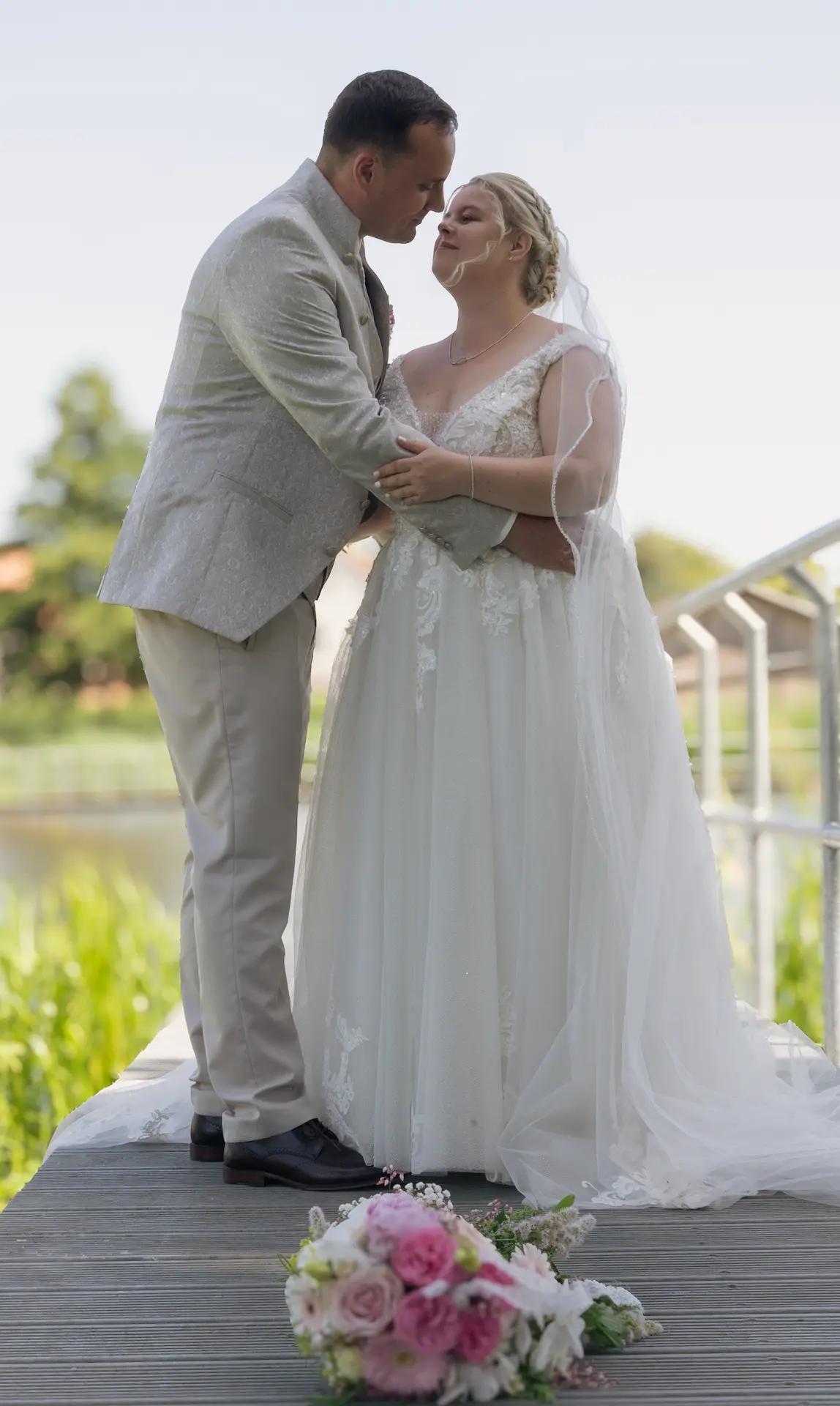 Hochzeitsfotografie: Glückliches Hochzeitspaar auf einem Steg schaut sich verliebt an.