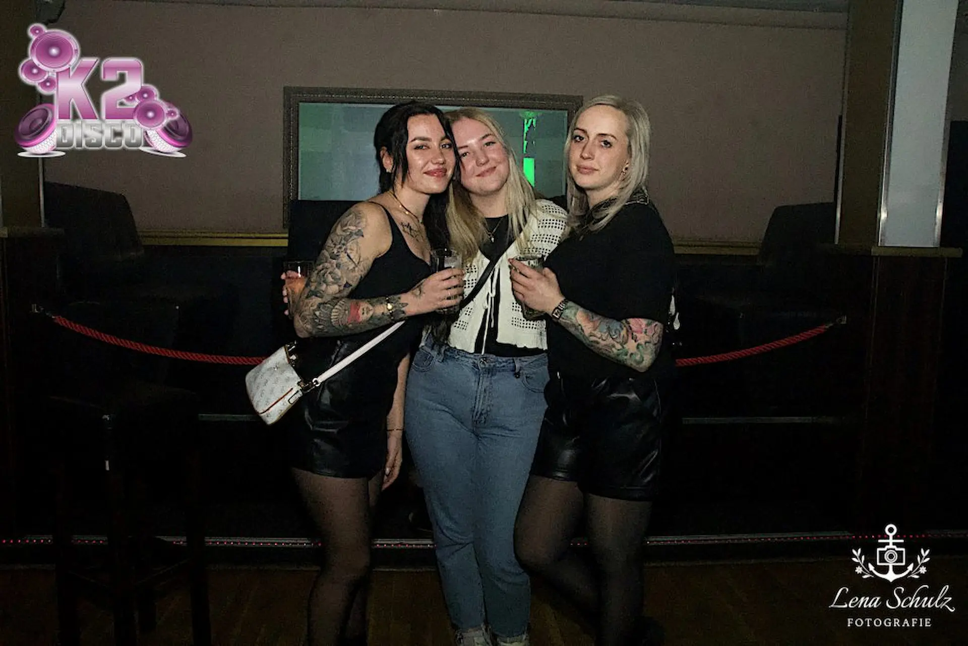 Event-Fotografie: Freundinnen die sich gegenseitig bei einer Party umarmen und ein Portrait von sich fotografieren lassen.